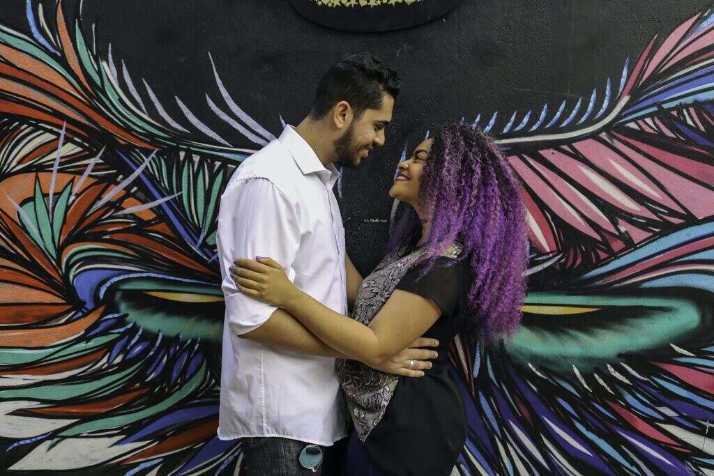 Couple Smiling Near Wall Art Work